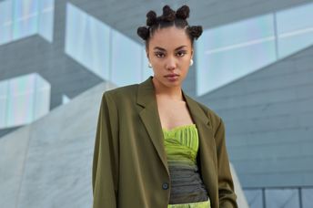 Stylish Millennial poses outdoors.