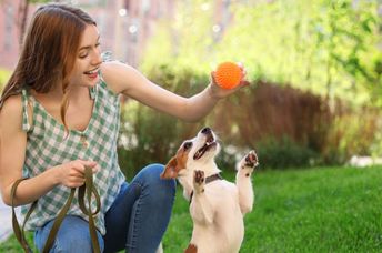 A woman playing with her dog.