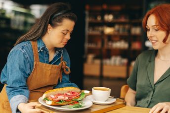 Waitress with down's syndrome serving a customer.