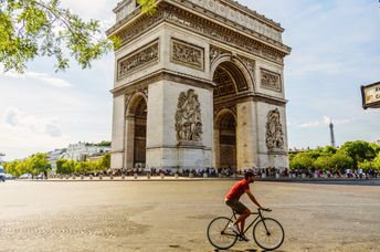 Man cycling near the Paris landmark Arc de Triomphe.