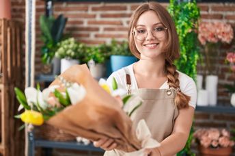 A young florist smiles for the camera.