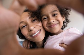 Mother and child making a heart together.