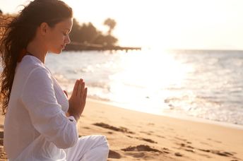 Practicing meditation on a beach.