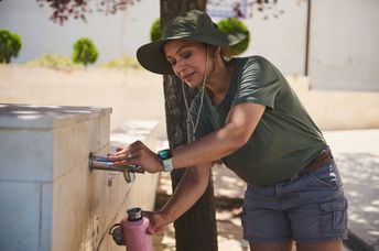 A woman refilling her reusable water bottle.