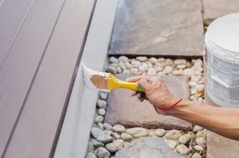 A person paints a structure.