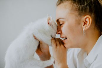 A woman holds a kitten.