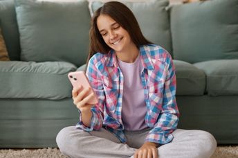 A teenage girl using an AI companion on her phone.