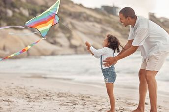 A father and daughter flying a kite.
