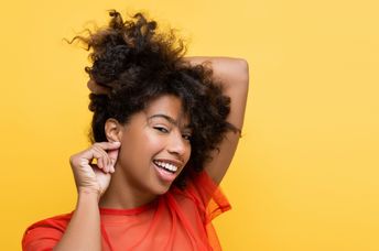 A woman touches her ear.