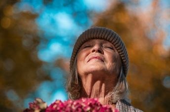 A senior woman expressing gratitude for all she has.
