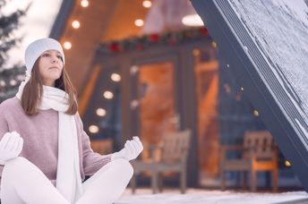 Woman meditating outside in winter.