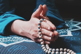 Woman meditating with a mala.