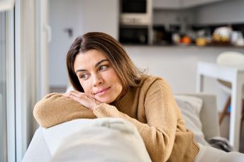 A woman sits on a sofa.