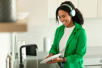 Woman listening to an audiobook while doing dishes.