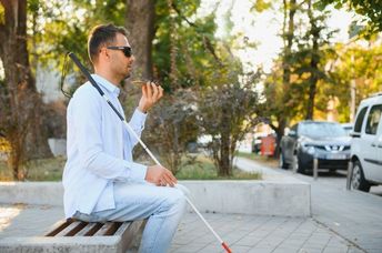 A partially-sighted man navigates public transport with the aid of technology.