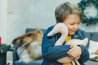 A boy hugs a plush toy.