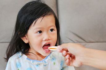 Girl taking her medicine.