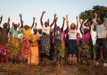 Kuli Kuli founder Lisa Curtis celebrates with female farmers in Nigeria.