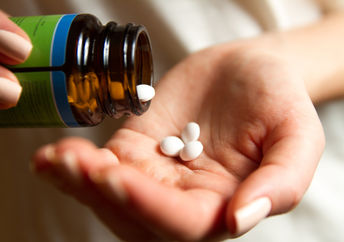 A young woman pours the pills out of the bottle