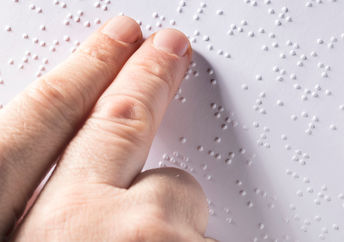 A blind person reads a tactile guide about solar eclipses