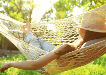 Happy woman relaxes in hammock