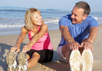 A couple stretching on the beach may have reduced hypertension.