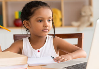 Khan Academy helps students with remote learning like this young girl studying online at home.