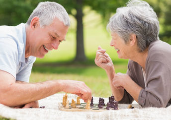 Retired couple playing chess, a brain game.