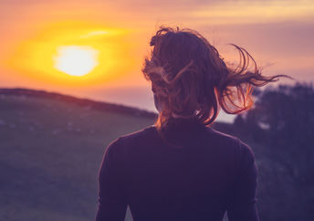 Woman on a mindfulness-inspired awe walk admiring the sunset