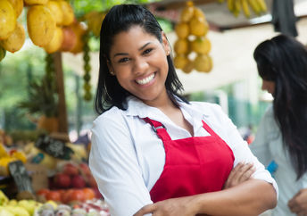 Latin American woman selling fruits and vegetables.