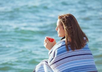 Woman sitting by the sea to manage stress