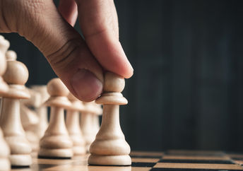 A player makes his opening move on a chessboard.