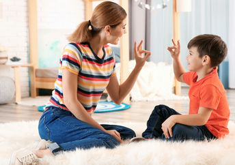 Mother using sign language with son.