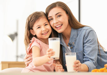 a mother and daughter enjoying vegan milk.