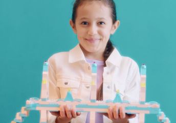 Girl proudly showcasing her LEGO creation