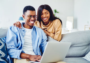 A couple looking at a website on their computer.