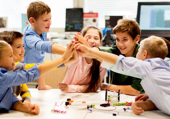 Happy children learning about tech at school