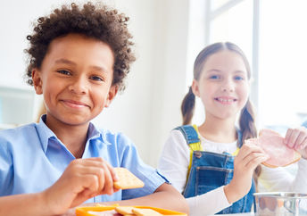 School kids eating snacks from containers at break