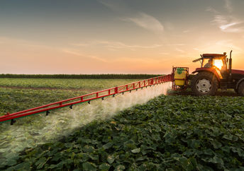Tractor spraying a vegetable field in the spring.