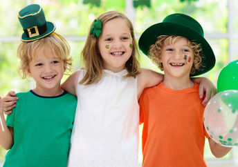 Children celebrate St. Patrick's Day by wearing a leprechaun hat and waving an Irish flag.