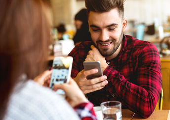 Couple using their mobile phones in a cafe.