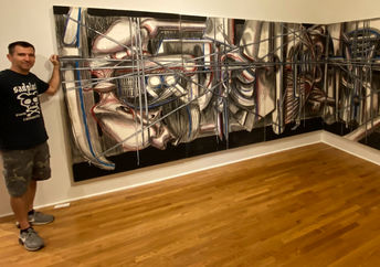 Jared Whipple stands in a gallery beside a Frances Hines painting.