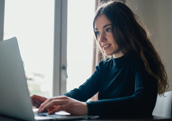 A young woman sitting with her laptop.