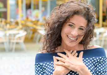 Grateful woman with her hands to her heart.