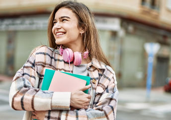 A young woman holding books.