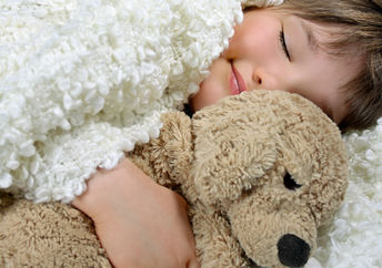 Smiling girl holding a precious soft toy.