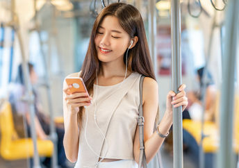 Young passenger listening to music during her commute.
