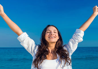 Happy woman by the beach.