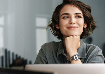 A smiling woman working on her laptop.