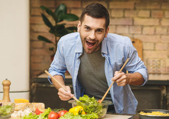 An enthusiastic chef cooks in the kitchen.